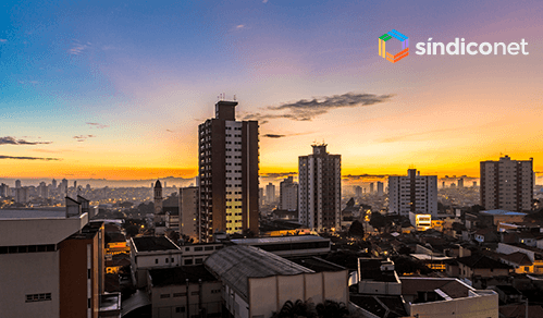 rateio de água em condomínio - vista urbana ao entardecer com prédios residenciais iluminados