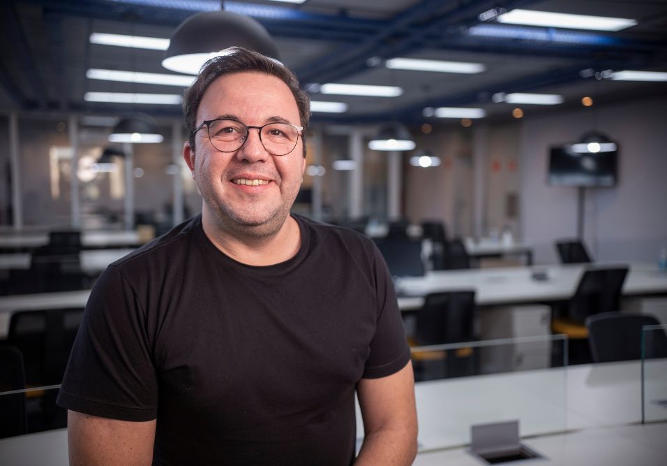 inteligência artificial condomínio - profissional sorridente em ambiente moderno de escritório representando inovação em gestão condominial